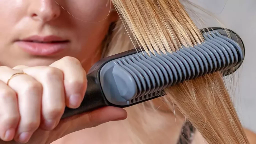 Mulher loira usando escova alisadora tipo pente
